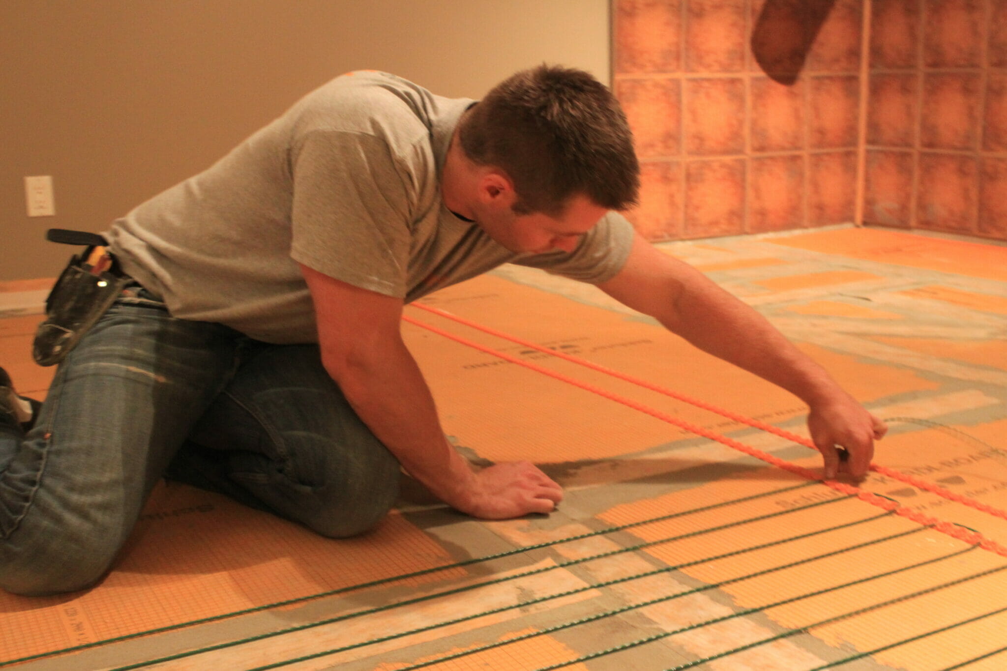 Image d'un entrepreneur posant des fils chauffants pour planchers chauffants